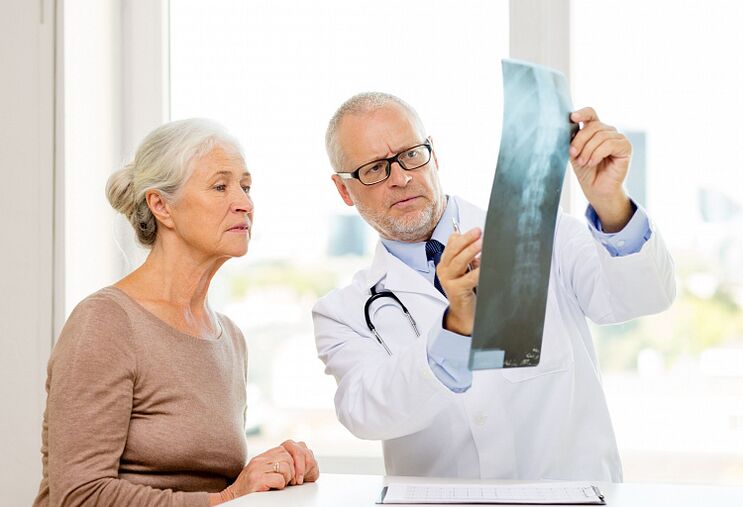 Der Arzt stellt bei einem Patienten mittels Röntgen eine zervikale Osteochondrose fest.